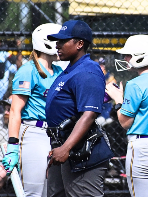 Softball action with umpire in frame